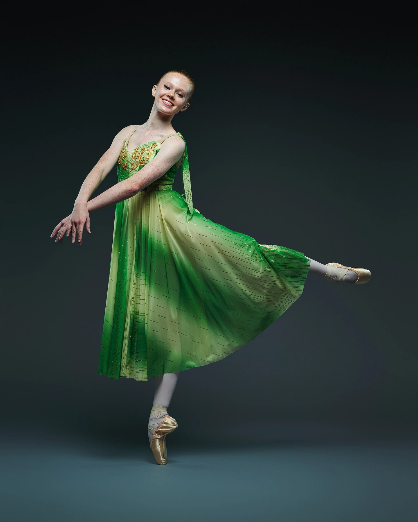 Ballet dancer in a flowing green and gold costume