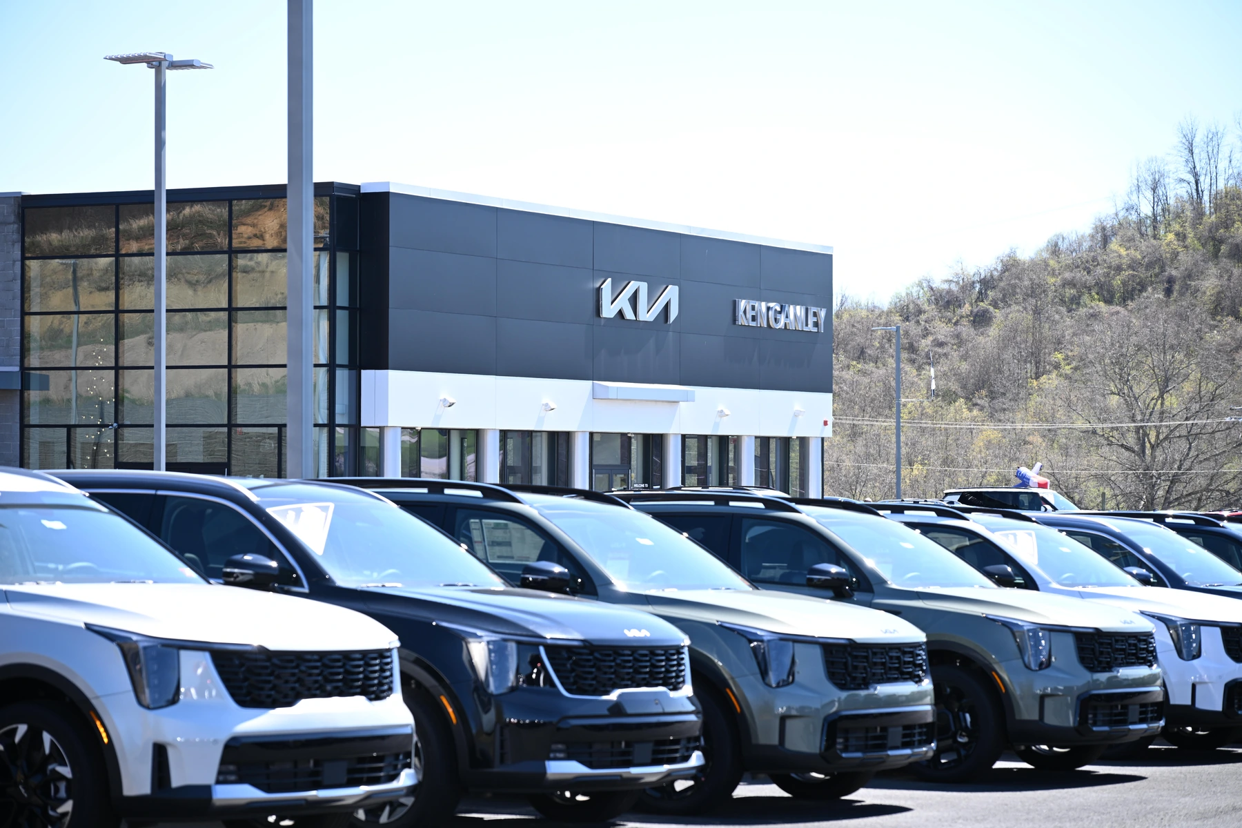 Row of Kia SUVs in front of the Ken Ganley Kia dealership