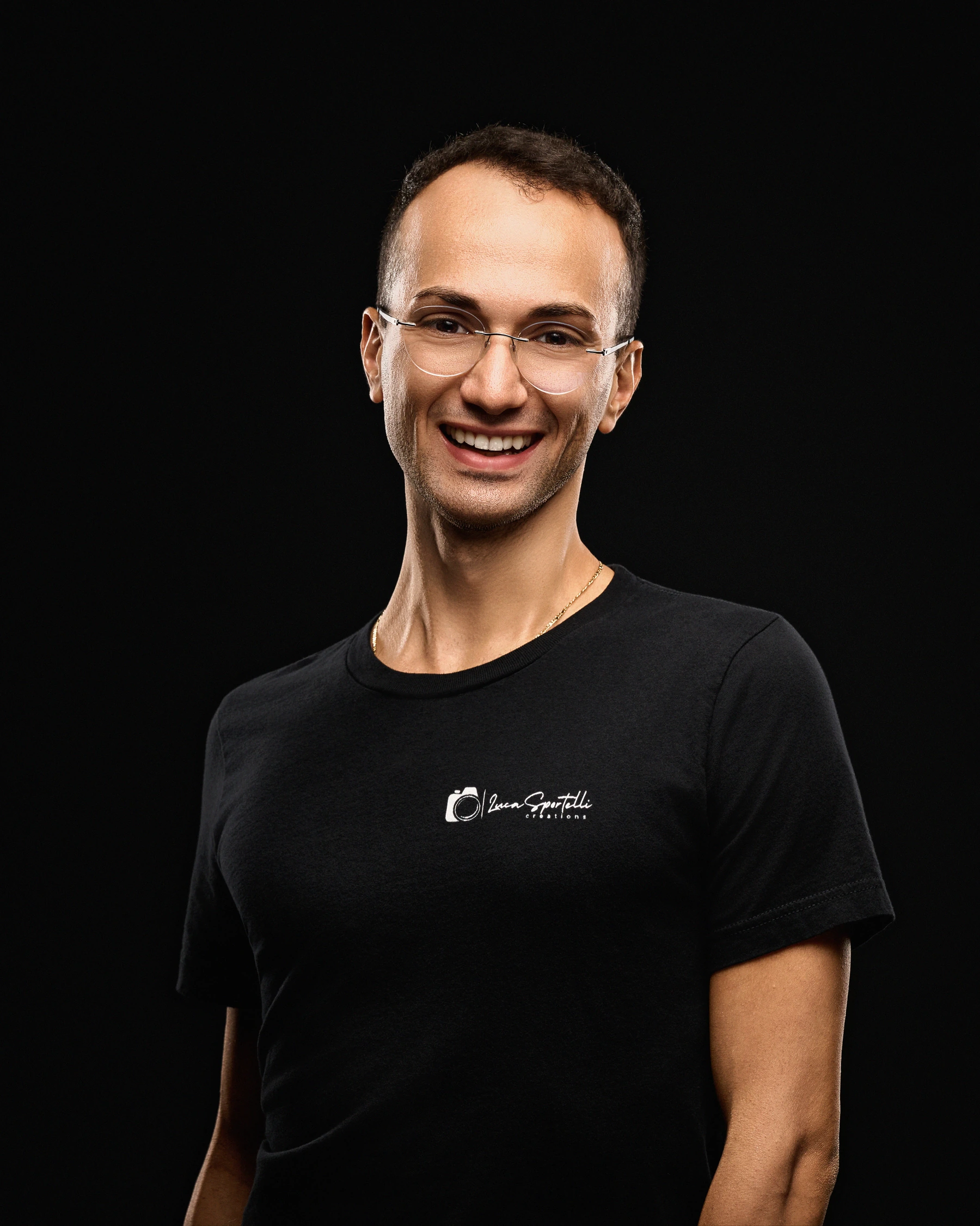 Luca Sportelli smiling in his studio, wearing a Luca Sportelli Creations shirt