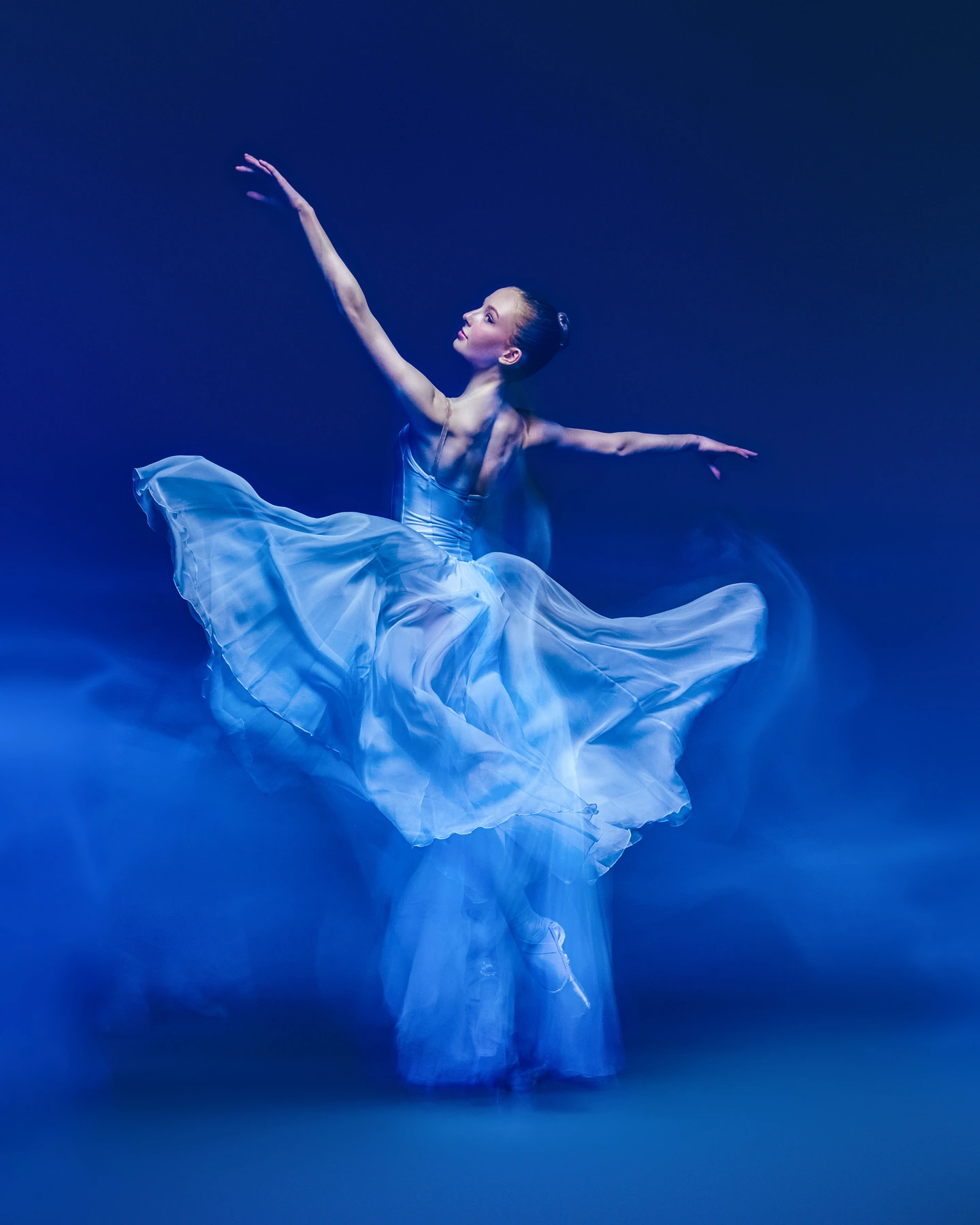 Ballerina in a flowing blue dress surrounded by blue motion trails