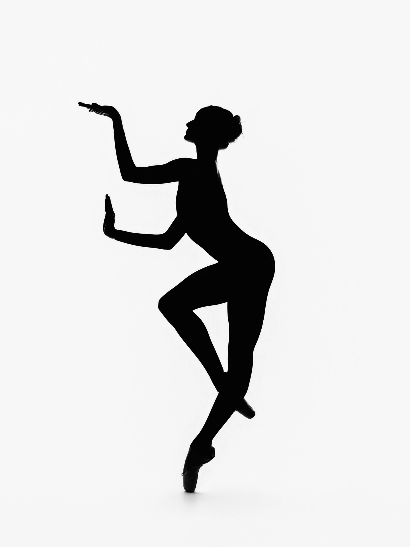 Graphic black silhouette of a dancer balancing against white