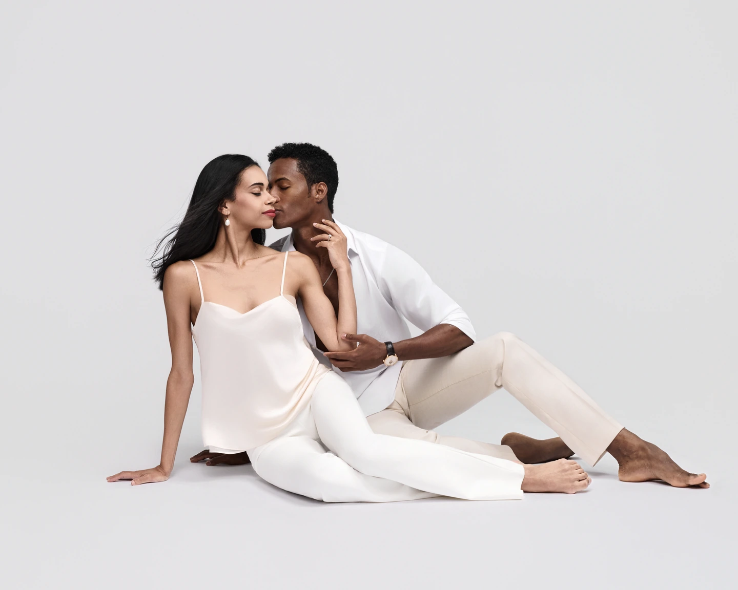 Couple seated together in white and cream against white
