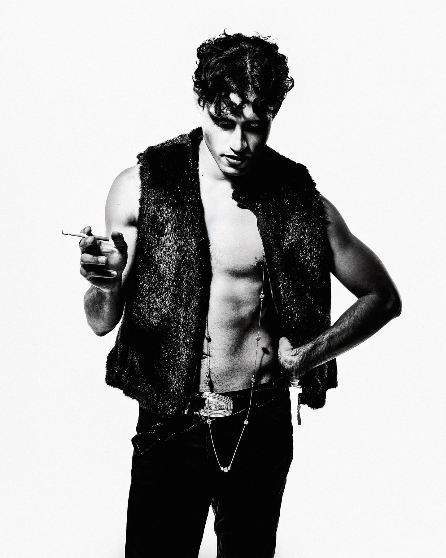 Black and white fashion portrait in a dark vest against white